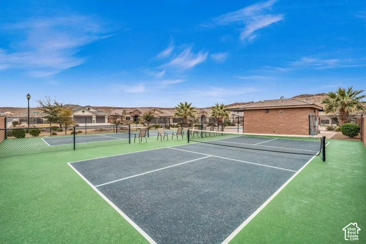 Dual pickleball courts featuring specialized surfacing, integrated netting, chain-link perimeter fencing, and exterior landscape lighting