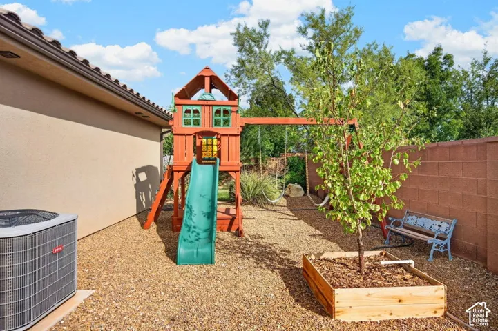 Side yard featuring decorative stone ground cover, a raised wood planter box, and a perimeter masonry wall