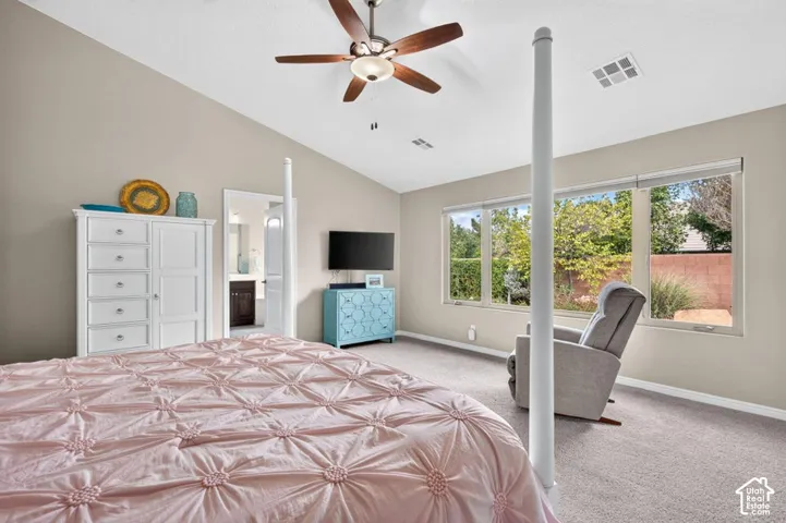 Vaulted ceiling room featuring neutral wall tones, large window configuration, and a ceiling fan with integrated lighting