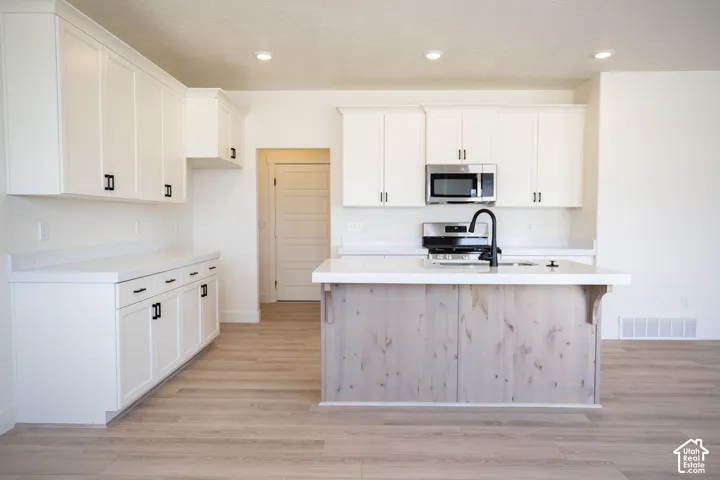 Terrific kitchen with 42" uppers, painted white wood cabinets, stained wood island, quartz slab countertops, walk-in pantry, gas range, microwave, dishwasher and disposal.