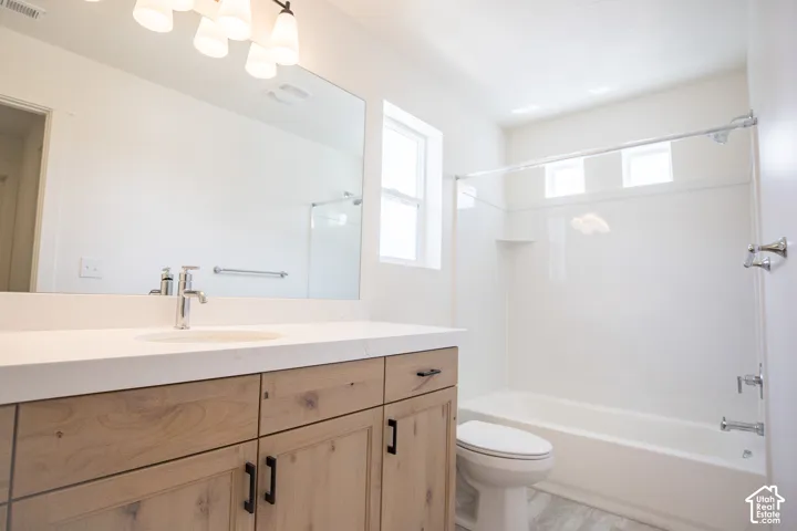 Full secondary bath with stained wood cabinet and quartz slab countertop.