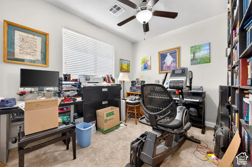 Room featuring neutral carpeting, a central ceiling fan with integrated lighting, and horizontal window blinds
