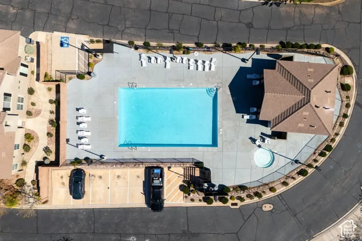 Community pool area featuring a rectangular swimming pool, integrated spa, concrete deck, and covered pavilion structure