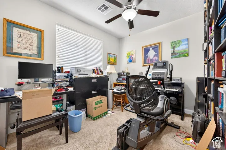 Room featuring neutral carpeting, a central ceiling fan with integrated lighting, and horizontal window blinds