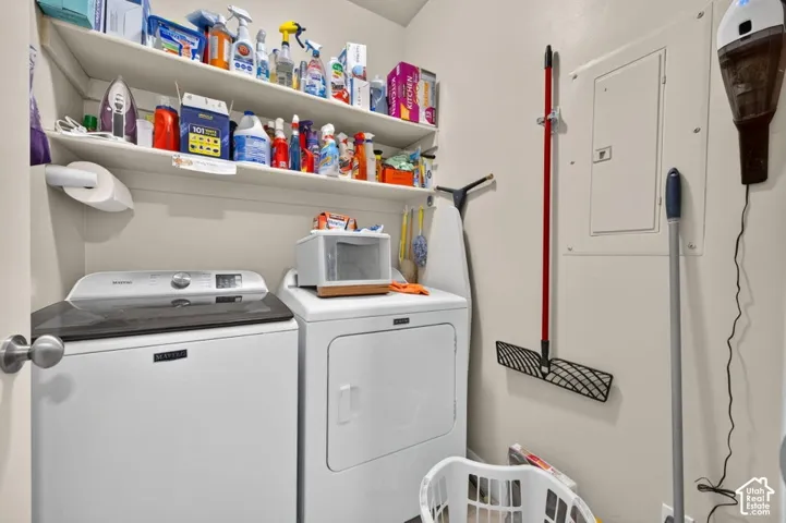 Dedicated laundry area featuring built-in shelving and an integrated electrical panel