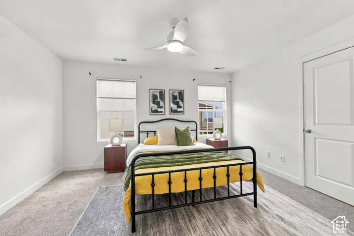 Neutral white wall paint, two paneled windows, ceiling fan with integrated lighting, and a white paneled door