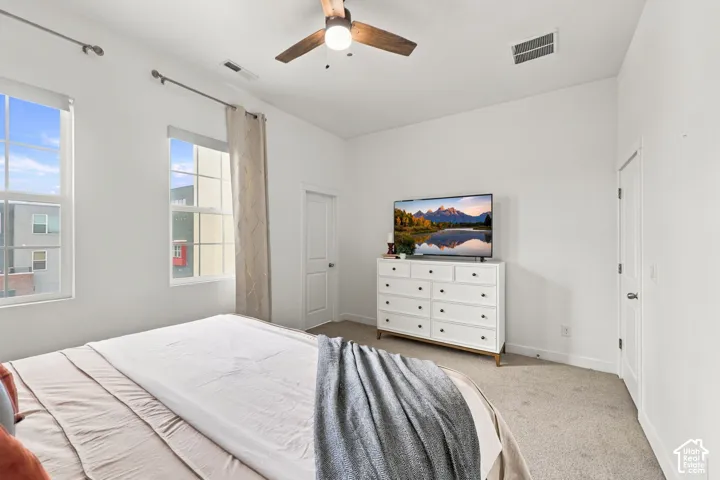 Vaulted ceiling with a wood-finish ceiling fan, recessed lighting, and two large windows