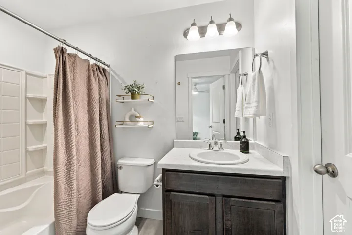 Bathroom featuring a white bathtub, dark wood-finish vanity with an integrated sink, and overhead vanity lighting