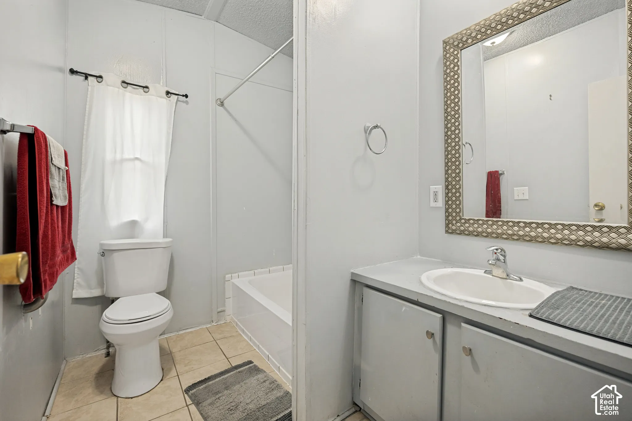 Bathroom featuring a vanity with an integrated sink, built-in lower cabinetry, a framed wall mirror, a toilet, and a shower/tub combination