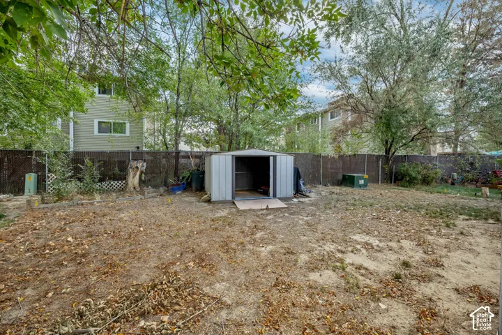 Expansive backyard featuring a metal storage shed and perimeter fencing