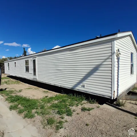Exterior featuring horizontal vinyl siding, a gabled roofline, and multiple vertical windows