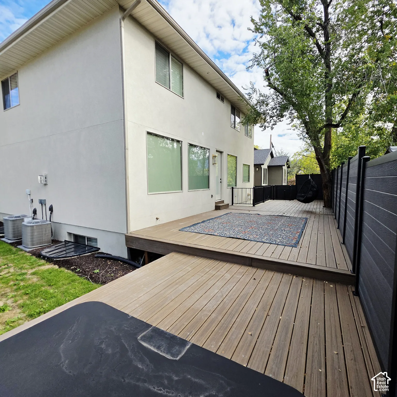 Multi-level composite deck featuring tiered platforms and a solid-panel privacy fence