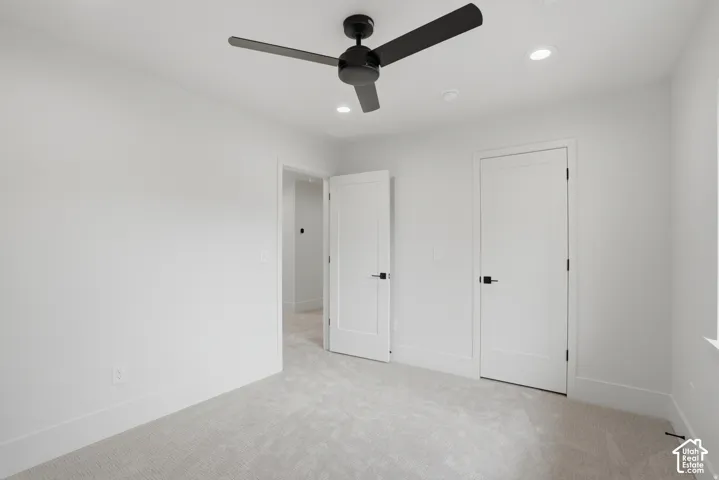 Interior space featuring neutral wall-to-wall carpeting, a matte black three-blade ceiling fan, recessed lighting, and white shaker-style interior doors with matte black hardware