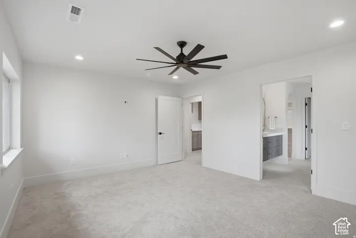 Neutral-toned wall-to-wall carpeting, recessed ceiling lighting, and a multi-blade matte black ceiling fan