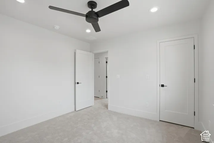 Room featuring recessed lighting, a matte black three-blade ceiling fan, neutral wall-to-wall carpeting, and solid-core interior doors with matte black hardware