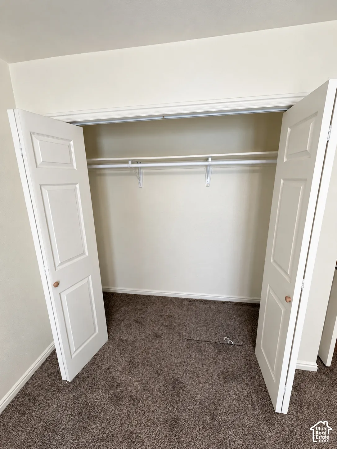 Built-in closet with dual paneled doors, wire shelving, and hanging rod