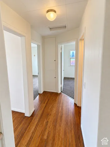 Wood-finish flooring, white paneled walls, flush-mount ceiling light fixture, and built-in storage cabinet