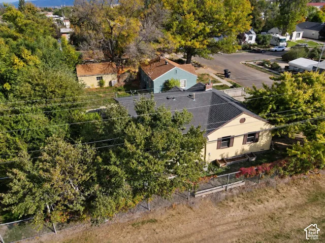 Single-story residence with a dark-pitched roof, light-colored siding, and dark window shutters