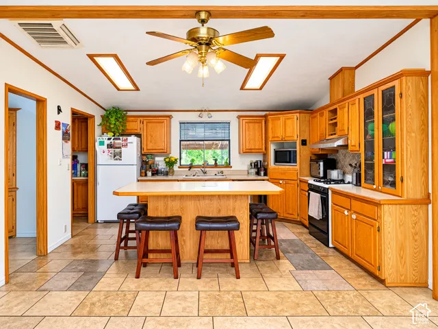 Kitchen featuring wood cabinetry, a central island with integrated seating space, recessed lighting, and tile flooring