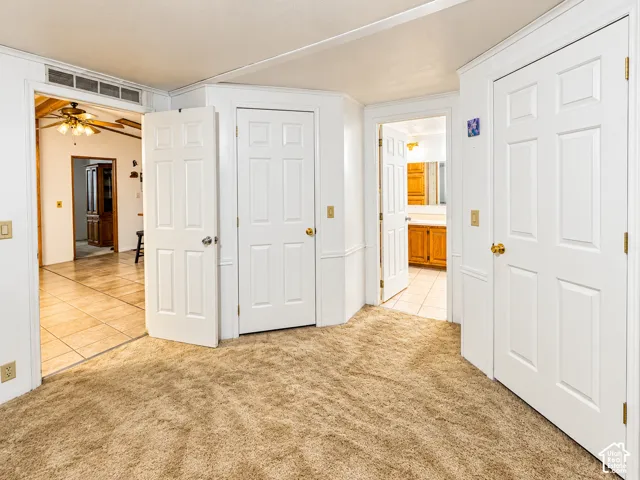 Neutral wall color, six-panel interior doors, beige carpeting, and tile flooring