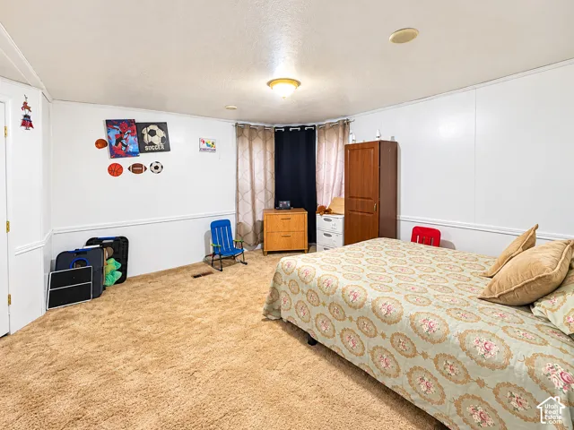 Room featuring neutral wall-to-wall carpeting, chair rail molding, and a bay window configuration