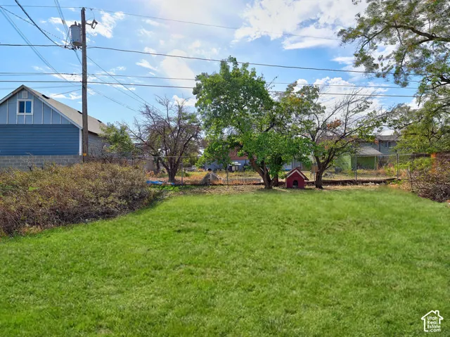 Expansive grassy area with mature trees and perimeter fencing
