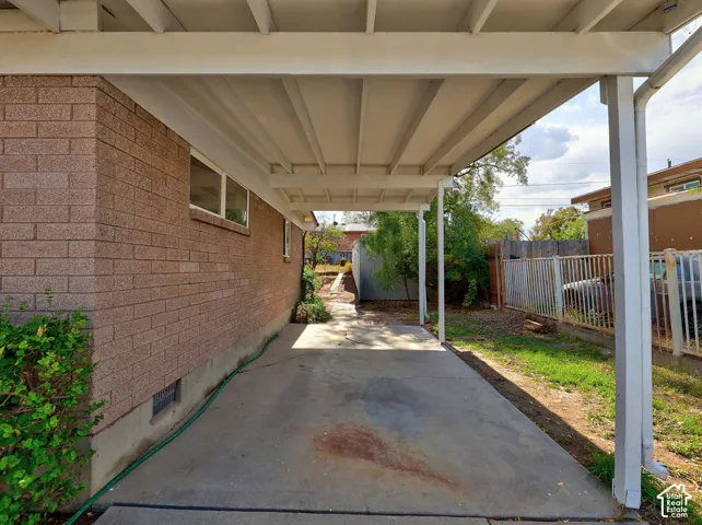 Covered concrete patio with a brick exterior wall