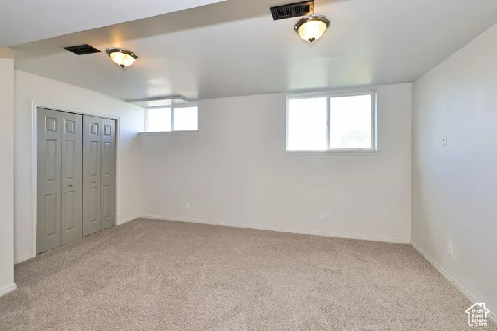 Plush carpeted flooring, bi-fold closet doors, and recessed windows provide functional design