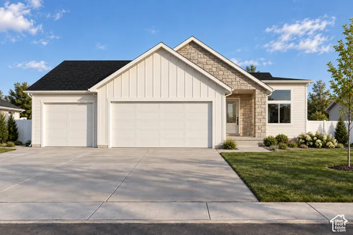 Exterior featuring vertical board-and-batten siding, stone masonry accents, a three-car garage, and concrete driveway