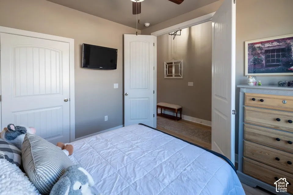 Neutral-toned room featuring two-panel arched interior doors, a ceiling-mounted light fixture, and an open doorway leading to a carpeted walk-in storage area