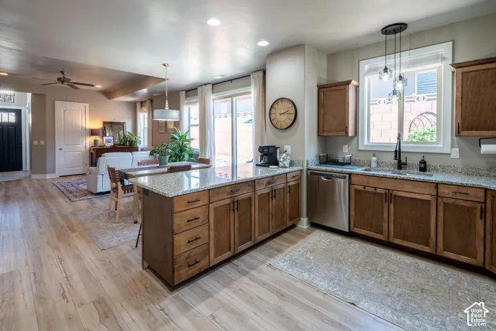 Kitchen featuring wood cabinetry, stone countertops, stainless steel dishwasher, wood-finish flooring, and recessed lighting