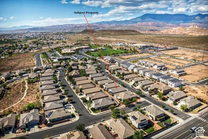 Aerial perspective of a residential property featuring a hipped roofline and a mountain backdrop