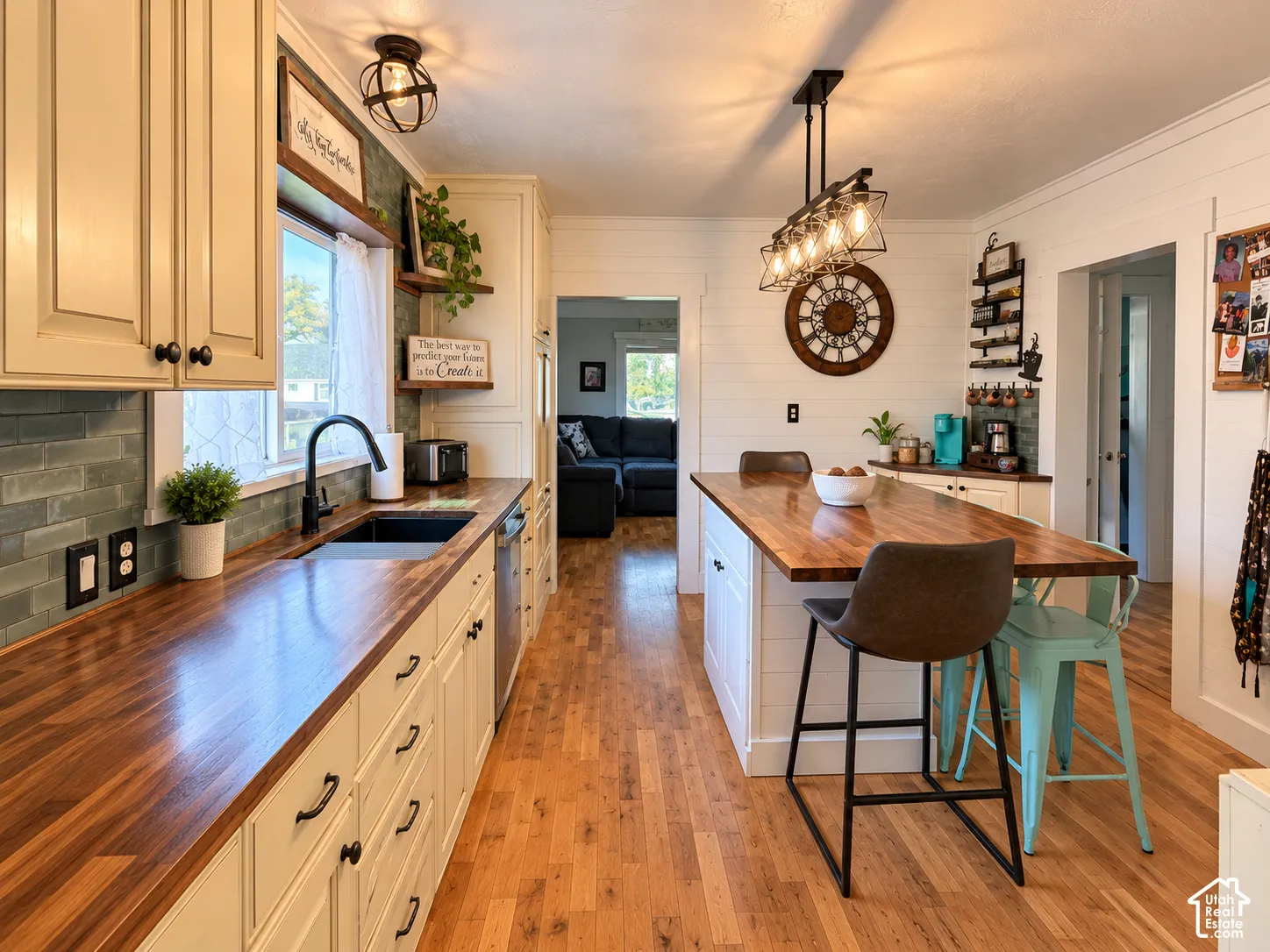 Kitchen featuring wood-finish countertops, shaker-style cabinetry, a central island with integrated seating, wood-finish flooring, and subway tile backsplash