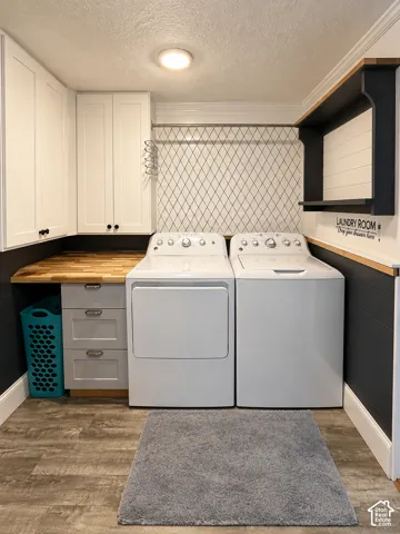 Laundry area featuring white shaker-style cabinetry, wood-finish countertop, three-drawer storage unit, patterned tile backsplash, and built-in wall shelving