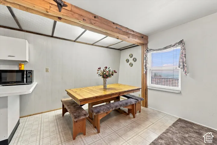 Exposed structural timber beam, tile flooring, and single-hung window with horizontal blinds