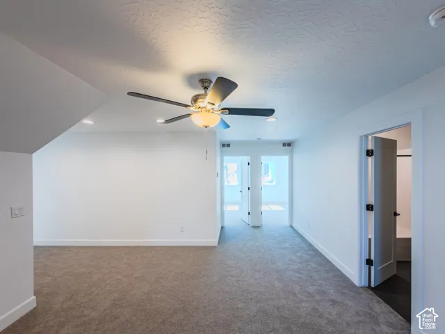 Neutral-toned carpeting, ceiling fan with integrated light fixture, recessed lighting, and white shaker-style interior doors