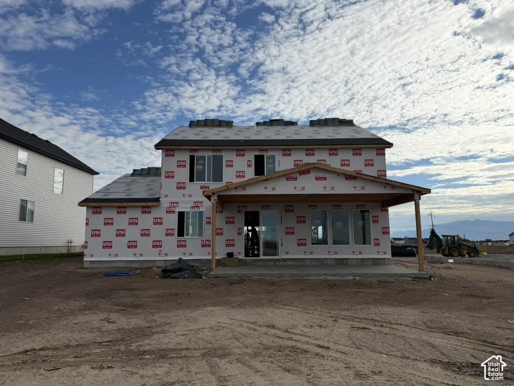 Two-story structural frame with a covered patio featuring a concrete slab foundation and wood support posts