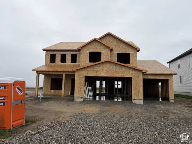 Two-story new construction residence featuring a wood-sheathed exterior, a multi-gabled roofline, a covered front porch, and an attached two-car garage