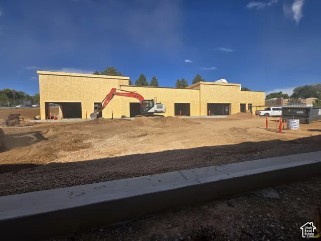 New construction property featuring an exterior frame of oriented strand board (OSB), multiple garage bays, and a concrete foundation
