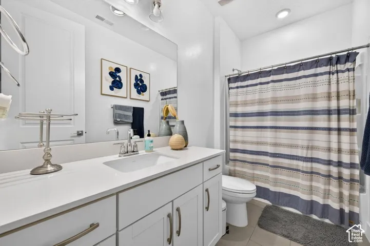 White vanity cabinetry with a stone-composite countertop, undermount rectangular sink, brushed-metal hardware, and a full-width mirror