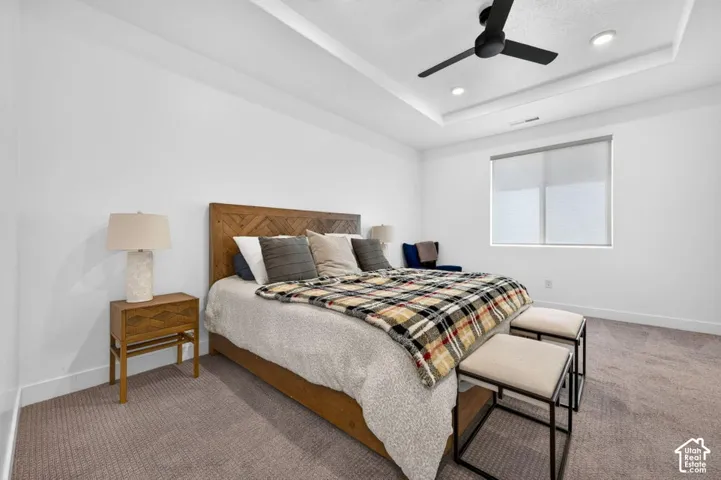 Room featuring a coffered ceiling, recessed lighting, a matte black ceiling fan, and neutral-tone carpeting