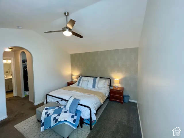 Vaulted ceilings, stylized patterned wallpaper, and a metal-finish ceiling fan with integrated light