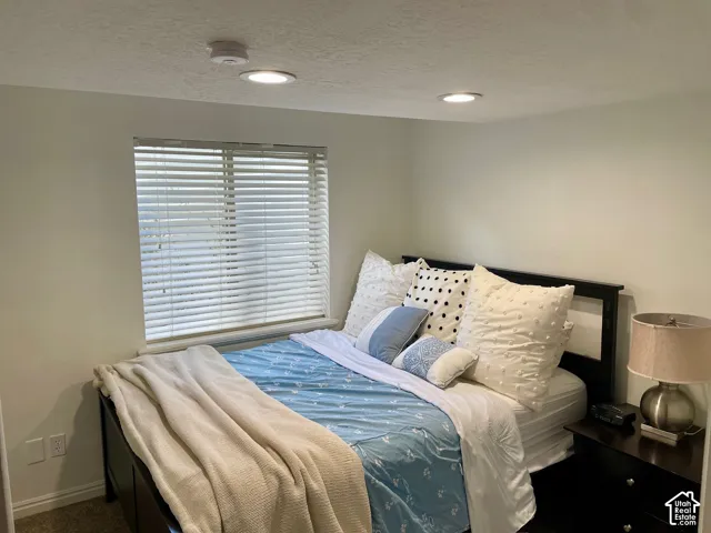 Room featuring recessed ceiling lighting, neutral wall paint, and a window with horizontal blinds