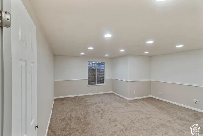 Interior room featuring recessed ceiling lighting, two-tone wall paint, chair rail molding, and neutral-toned wall-to-wall carpeting
