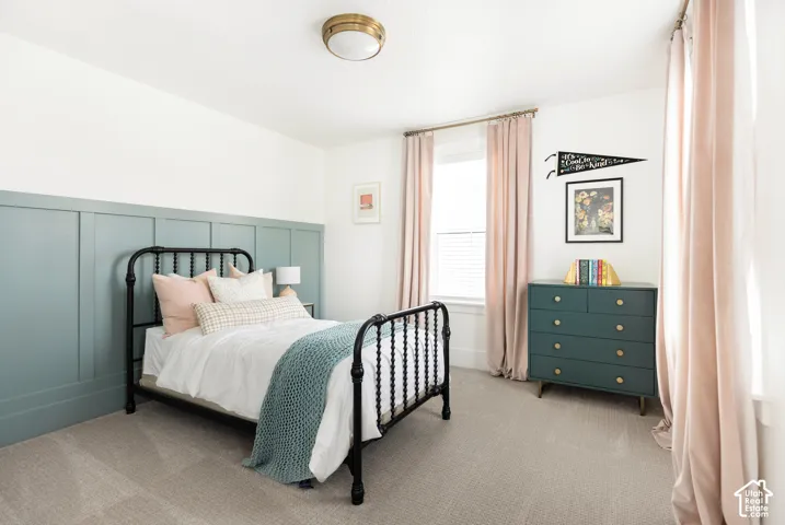 Wall paneling with a blue-green finish, brass-toned flush mount ceiling light, and window with blinds