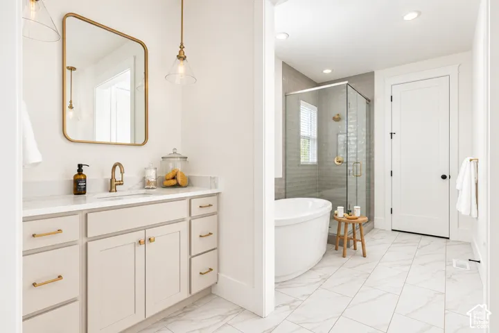 Vanity with a light-toned cabinet, gold-finish hardware, and a white countertop