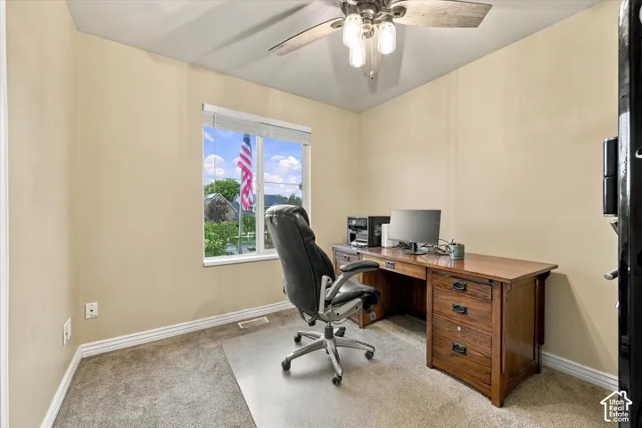 Neutral-toned room featuring a single-pane window, carpeted flooring, and a ceiling-mounted light fixture with frosted glass shades