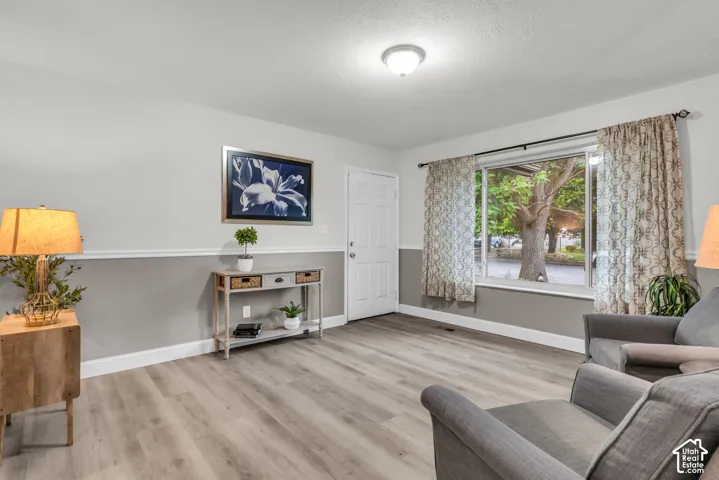 Wood-finish flooring, two-tone wall paint with chair rail molding, and a large picture window