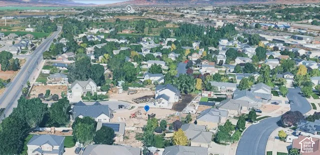 Aerial perspective of a residential neighborhood featuring cul-de-sac positioning, mature tree canopies, and mountainous horizon topography