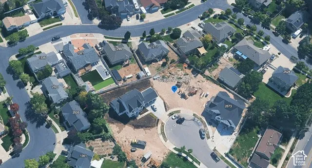 Aerial perspective of a cul-de-sac lot featuring graded terrain and placement within an established residential neighborhood